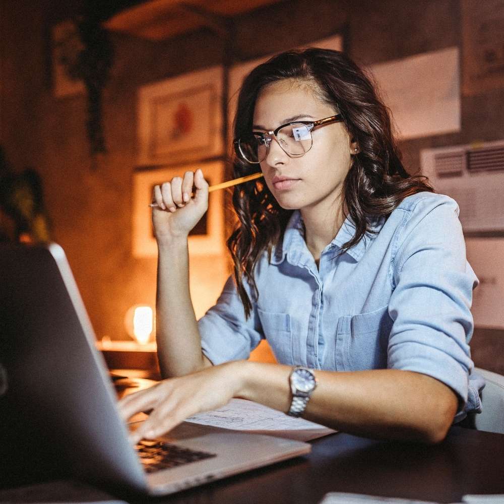 Frau am Laptop bei Nacht – steht für Fokus, Reflexion und Eigenverantwortung bei Schichtarbeit.